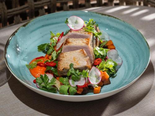 a blue plate with a salad with meat and vegetables at Mercure Ponta Delgada Azores in Ponta Delgada