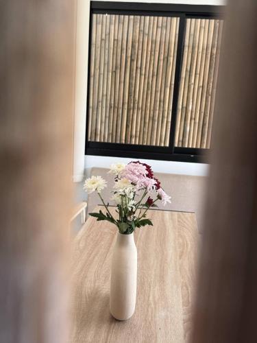 a vase with flowers sitting on a table in a window at Southwayhome in Koh Phangan