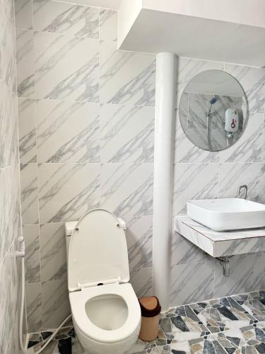 a bathroom with a white toilet and a sink at Southwayhome in Koh Phangan