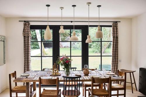 une salle à manger avec une table et des chaises et une grande fenêtre dans l'établissement Country House With Pool Near Rambouillet, 40 Min From Paris, à Gambais