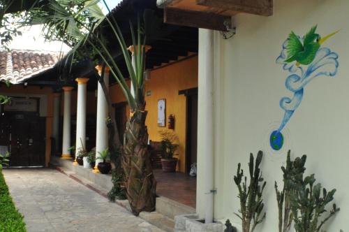 a house with a palm tree painted on the side of it at Rossco Hostel & Hotel in San Cristóbal de Las Casas