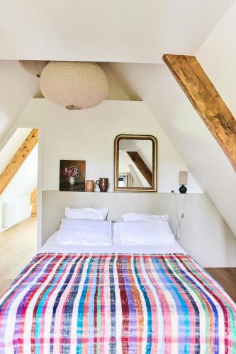 - une chambre avec un lit et une couverture rayée colorée dans l'établissement Country House With Pool Near Rambouillet, 40 Min From Paris, à Gambais