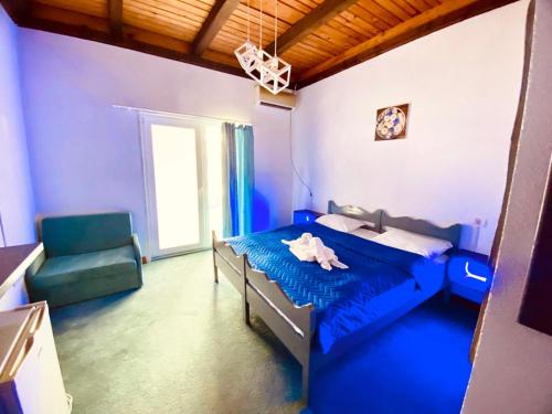 a bedroom with a blue bed and a chair at HOTEL KM 0 in Costinesti