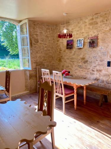 une salle à manger avec une table et des chaises en bois dans l'établissement Maison as Cambous, à Sauveterre-la-Lémance