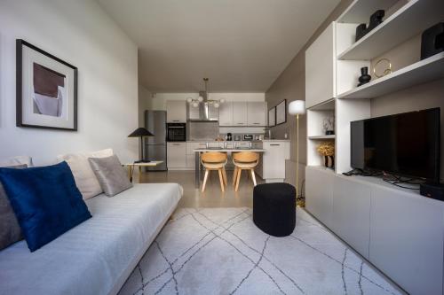 un salon avec un canapé et une cuisine dans l'établissement Appartement Rénové avec Style au Cœur d'Annecy, à Annecy