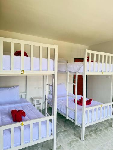 a room with three bunk beds in a room at Southwayhome in Koh Phangan