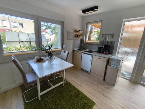 a kitchen with a white table and chairs and windows at Ferienhaus in guter Lage in Dresden