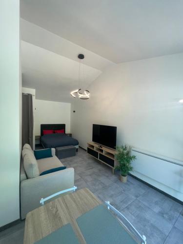 un salon avec un canapé et une télévision dans l'établissement Maison avec grand espace en hauteur, à Saint-Georges-des-Côteaux