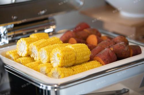 Una bandeja de maíz y otras frutas y verduras. en Atour Hotel Guangzhou Huangpu Luogang Science City, en Guangzhou