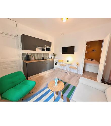 un salon avec un canapé vert et une table dans l'établissement Le cocon pop, à Reims