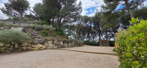 a stone wall and a gate in a yard at Les dentelles Évasion Provençale Villa avec Piscine et jardin in Carpentras