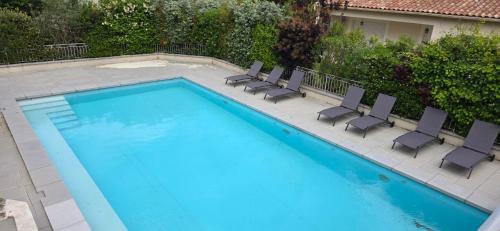 a swimming pool with chairs and a swimming pool at Les dentelles Évasion Provençale Villa avec Piscine et jardin in Carpentras