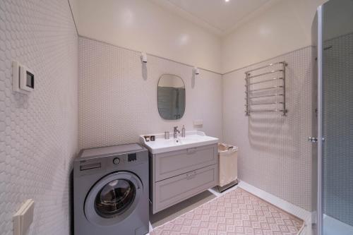 リガにあるCharming flat with beautiful riverside viewsの洗濯機と洗面台を備えたバスルーム