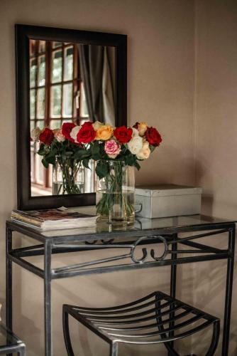 a table with a mirror and flowers in vases on it at Thulamela Couples Retreat in Hazyview