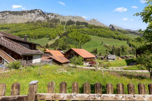 a village with a fence and mountains in the background at Famille et Nature dans un Chalet Traditionnel in Im Fang