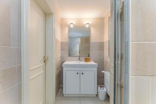 a bathroom with a white sink and a mirror at Appartement Salzwiese in Tinnum