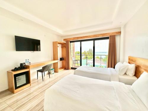 a hotel room with two beds and a television at AIMI Beach Hotel in Gulhi