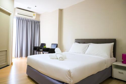 a bedroom with a large white bed in a room at CU iHouse เรือนวิรัชมิตร in Bang Rak