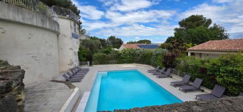 une piscine avec des chaises longues et une maison dans l'établissement Paradis Provençal Villa - Espace Détente et BBQ LMV, à Carpentras