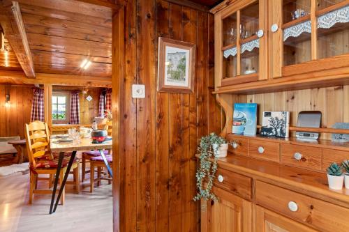a kitchen and dining room with wooden walls and a table at Famille et Nature dans un Chalet Traditionnel in Im Fang