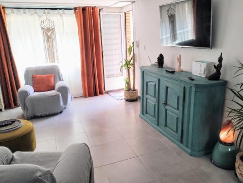 a living room with a green cabinet and a chair at Double Room with Private bathroom in Luxury Boho Chic Shared Apartment in Denia