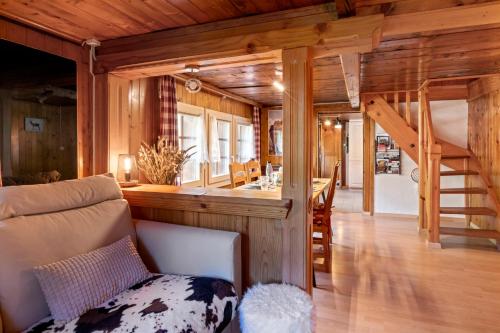 a living room with a staircase in a log cabin at Famille et Nature dans un Chalet Traditionnel in Im Fang
