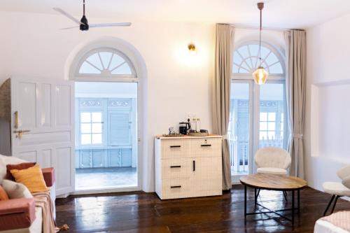 a living room with a dresser and two windows at FeelHome in Cochin