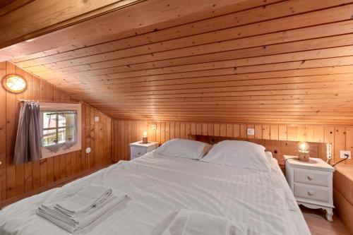 a bedroom with a large bed in a wooden room at Famille et Nature dans un Chalet Traditionnel in Im Fang