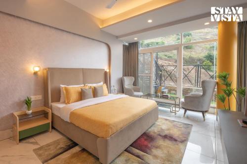 a hotel room with a bed and a balcony at StayVista at The Himalayan Echo with Lawn, Bonfire in Nainital