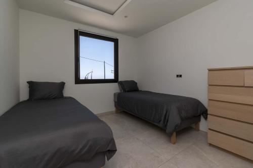 a bedroom with two beds and a window at The Stables in Arona