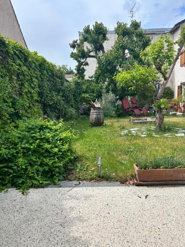 une cour avec un jardin avec des chaises et des arbres dans l'établissement Grand studio en rez-de-jardin, à Flins-sur-Seine