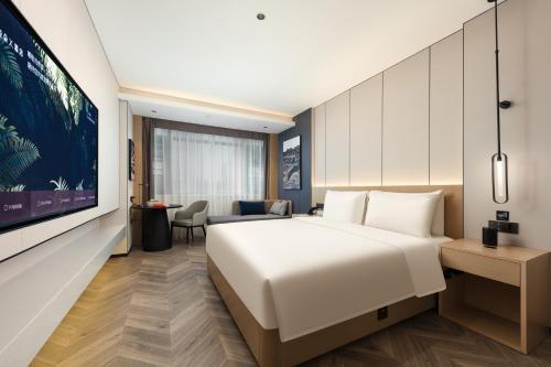 a hotel room with a large bed and a desk at Atour X Hotel Chengdu Jinhua Wanda Zhonggang Plaza in Chengdu