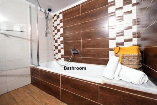 a bathroom with a tub and a shower with towels at Grand Lux Apartment in Serres
