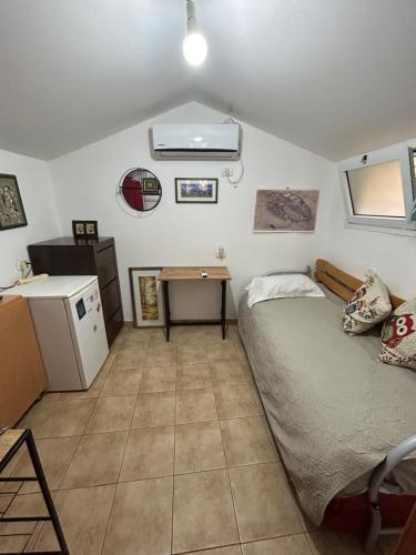 a small bedroom with a bed and a desk at Panorama Kinneret נוף כנרת, צפת in Safed