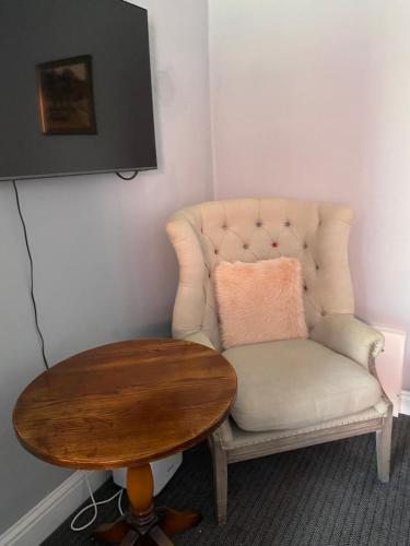 a table and a chair with a wooden table and a table at The Kings Head in Cheddar