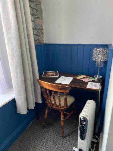 a desk with a chair next to a blue wall at The Kings Head in Cheddar