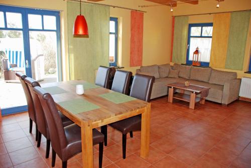 a dining room with a table and chairs and a couch at Ferienappartements zum Ostseestrand mit Terrasse in Lobbe