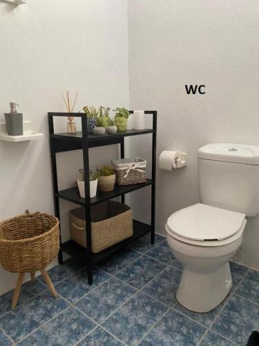 a bathroom with a toilet and a shelf with plants at Grand Lux Apartment in Serres