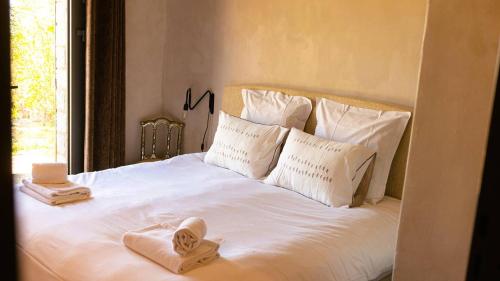 a white bed with two towels on top of it at Domaine de Gialla Bergerie Carta, 6 pers, montagne, vue mer in Porto-Vecchio