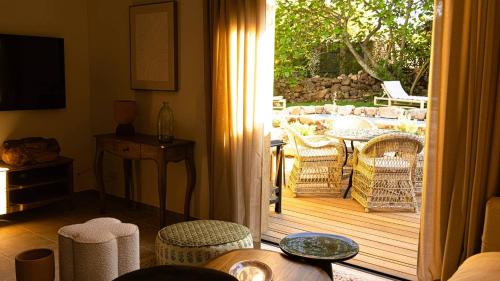 - un salon avec une porte s'ouvrant sur une terrasse dans l'établissement Domaine de Gialla Bergerie Figa, 2 pers, piscine chauffée, 10 mn plage, à Arraggio