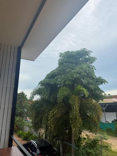 a palm tree in front of a house with a car at Southwayhome in Koh Phangan