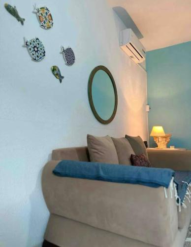 a living room with a couch and a mirror at Sea View Appartement a la Marsa plage in Douar el Hafey