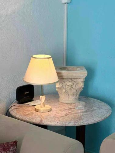 a table with a lamp and a phone on it at Sea View Appartement a la Marsa plage in Douar el Hafey