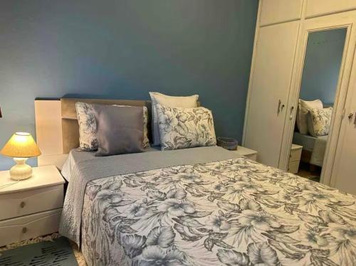 a bedroom with a bed and a lamp and a mirror at Sea View Appartement a la Marsa plage in Douar el Hafey