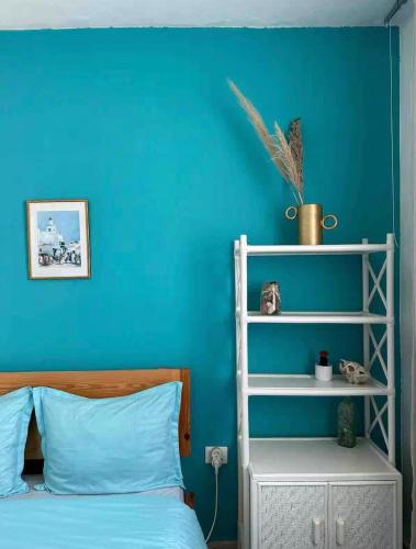 a blue bedroom with a bed and a blue wall at Sea View Appartement a la Marsa plage in Douar el Hafey
