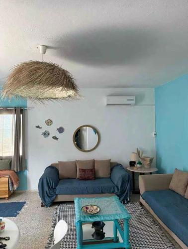 a living room with a blue couch and a table at Sea View Appartement a la Marsa plage in Douar el Hafey