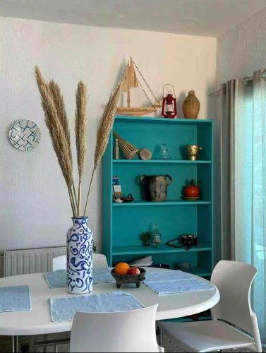 a dining room with a table and a blue shelf at Sea View Appartement a la Marsa plage in Douar el Hafey