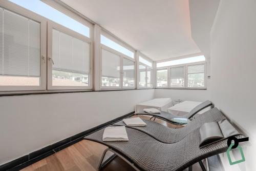 a room with a table and chairs and windows at HOTIDAY Room Collection - Alassio Centro in Alassio