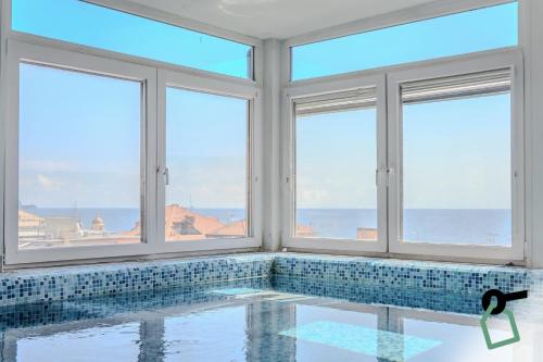 a room with a swimming pool with windows at HOTIDAY Room Collection - Alassio Centro in Alassio