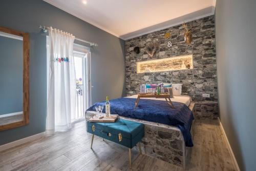 a bedroom with a bed and a stone wall at Y Palmela - Boutique Apartments in Palmela